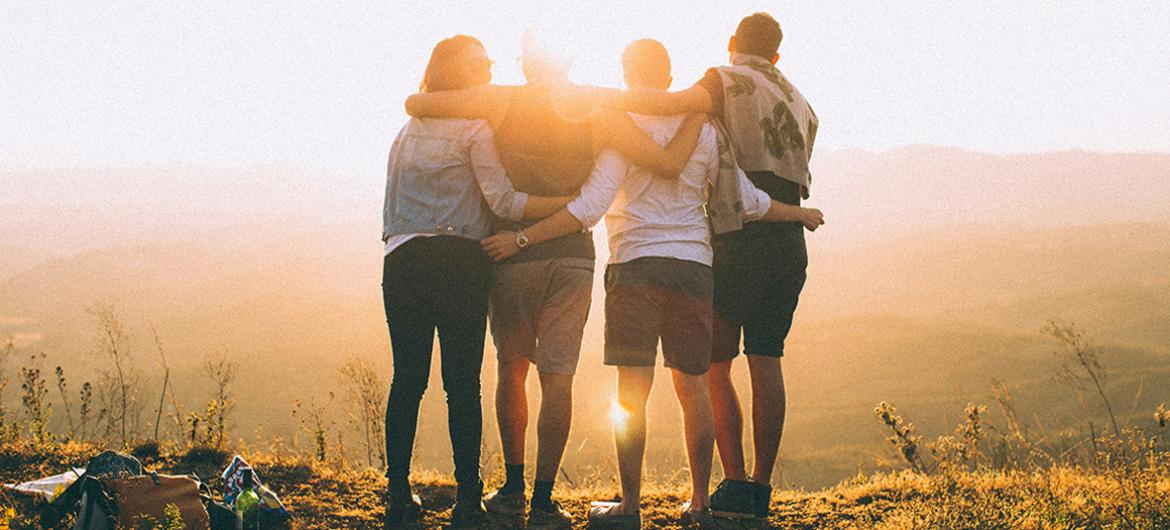 people holding together looking a nice sunset. 